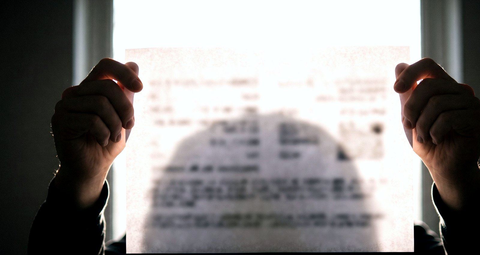 A printed page held up against a bright window