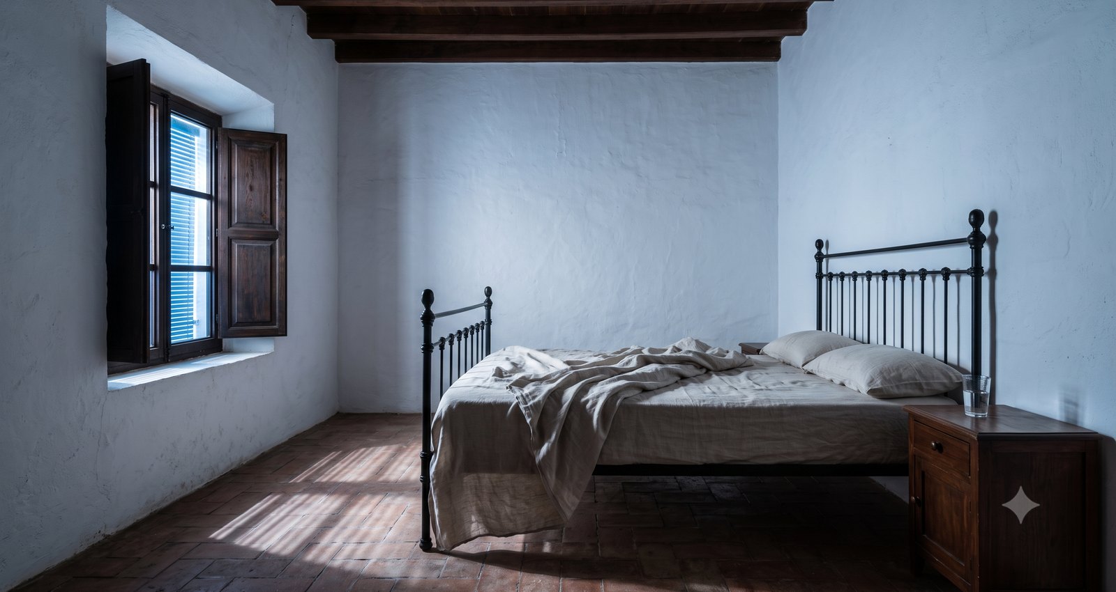 Een Andalusische slaapkamer bij het eerste licht met de lakens aan één kant teruggeslagen